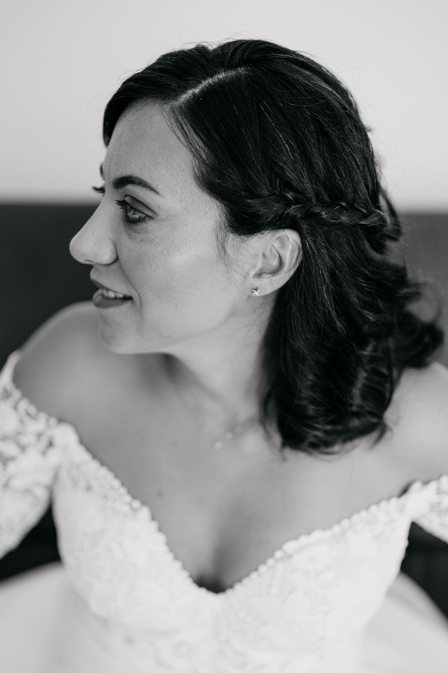 Close-up profile views of a bride's classic updo hairstyle and lace wedding dress.