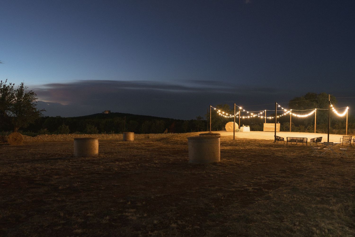 String lights create a romantic ambiance across a desert landscape at twilight.