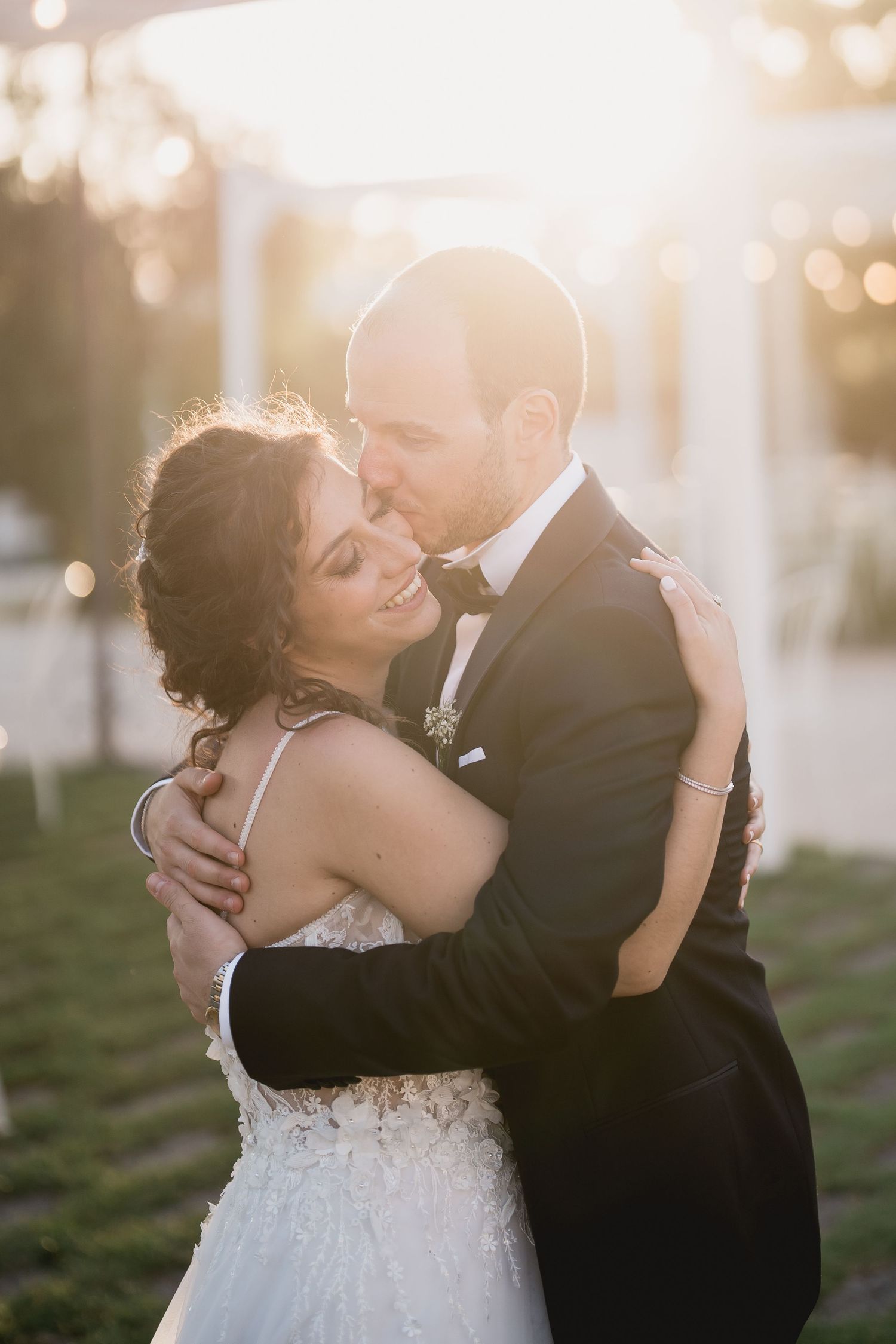 A romantic sunset embrace between newlyweds with soft bokeh lighting.