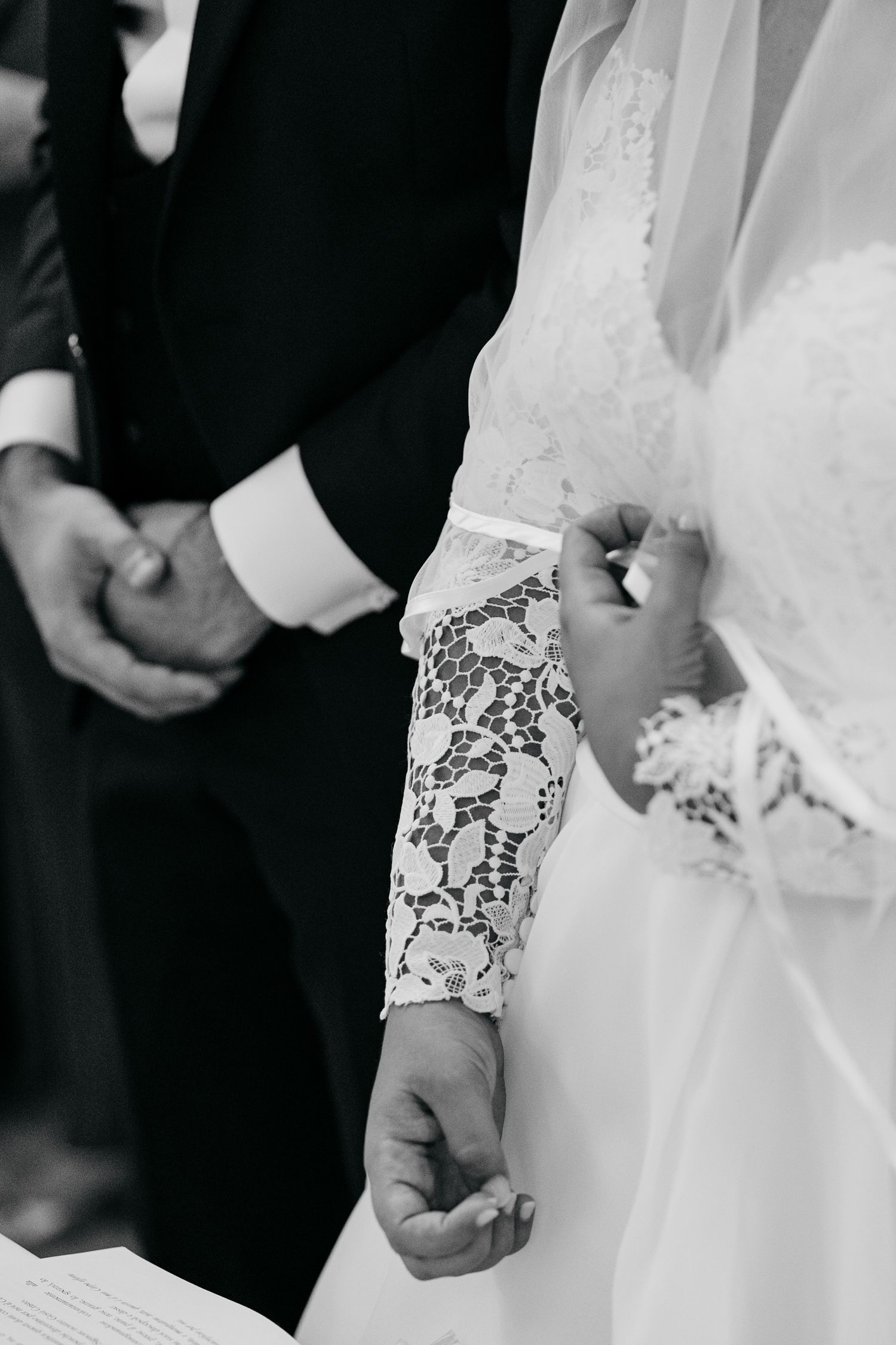 Close-up sequence of hands wearing delicate lace sleeves during a wedding ceremony.