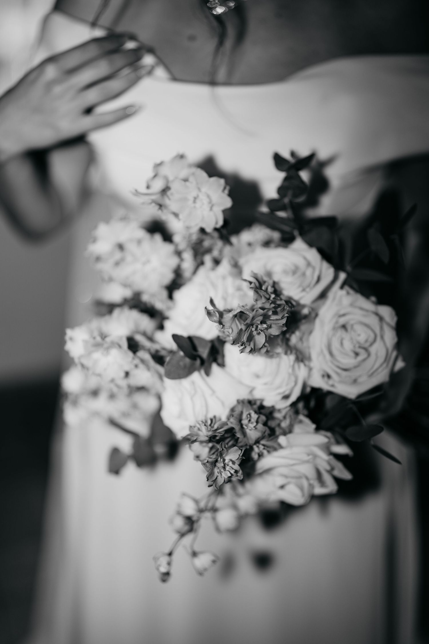 Elegant black and white detail shots of wedding floral arrangements featuring roses and mixed blooms.