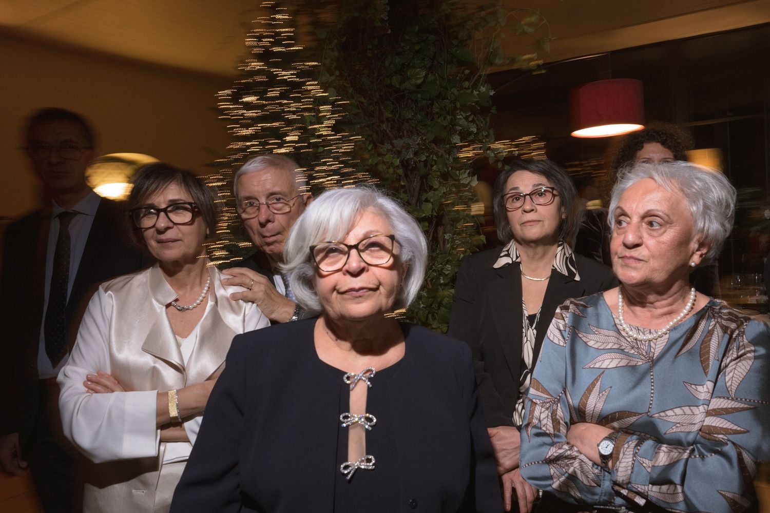 Group of elegantly dressed older guests posing together at a formal wedding reception event.