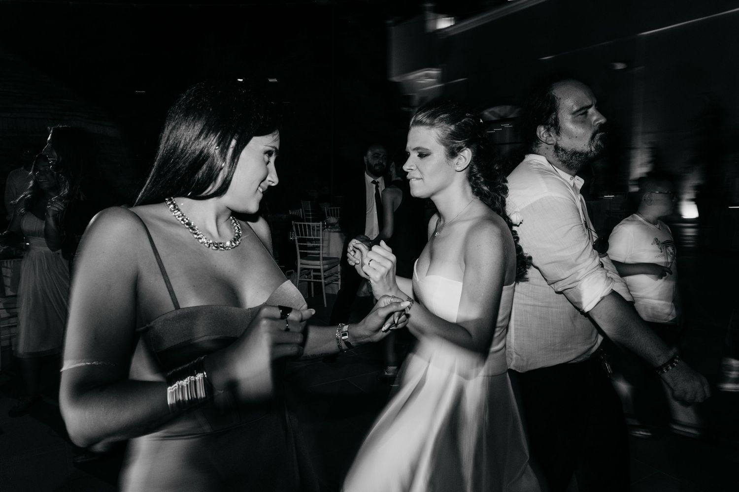Two guests enjoying a dance at an evening wedding reception in black and white.