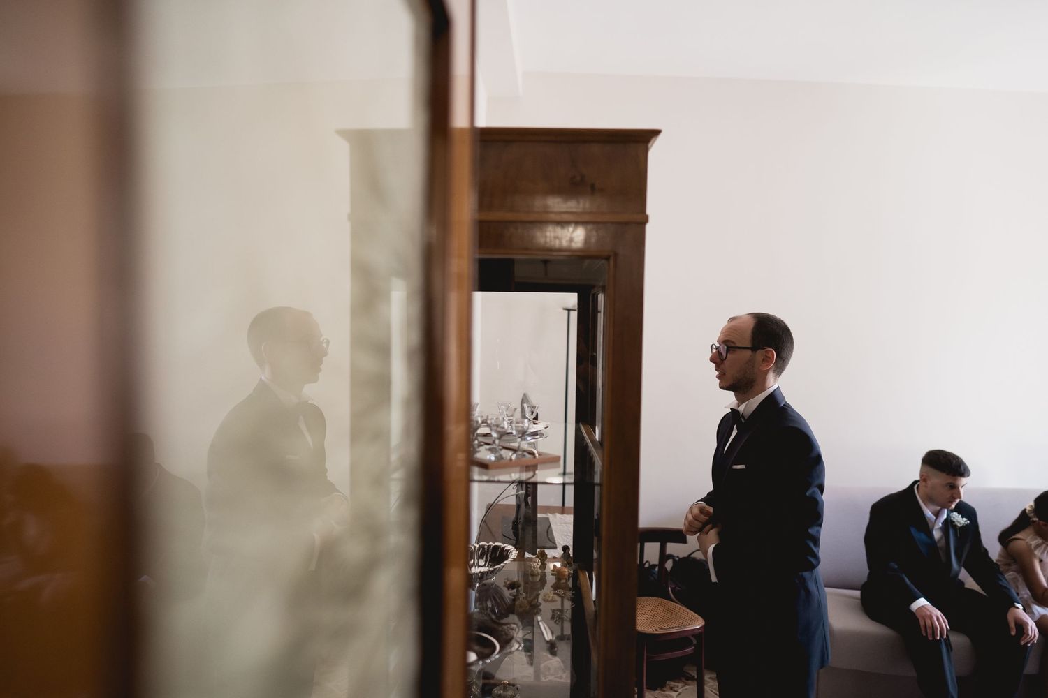 Atmospheric shot showing silhouettes and shadows of people in a dimly lit room.