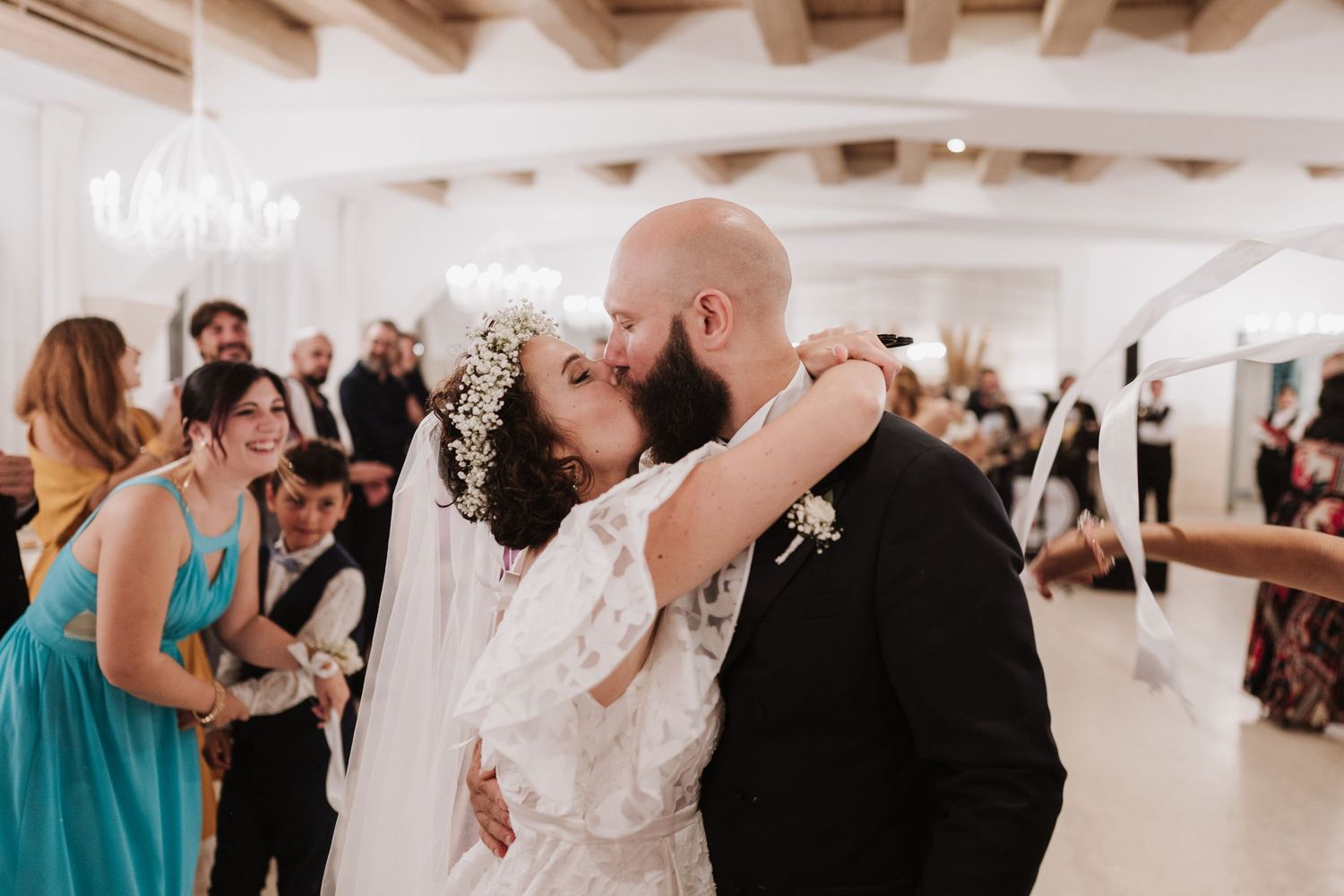 Dancing moment at an indoor wedding reception with exposed beam ceiling and elegant decor.