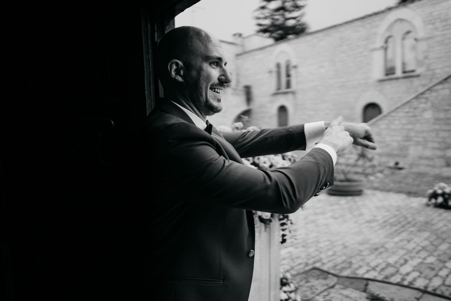 Black and white photo of a wedding ceremony setup with rows of chairs outdoors.