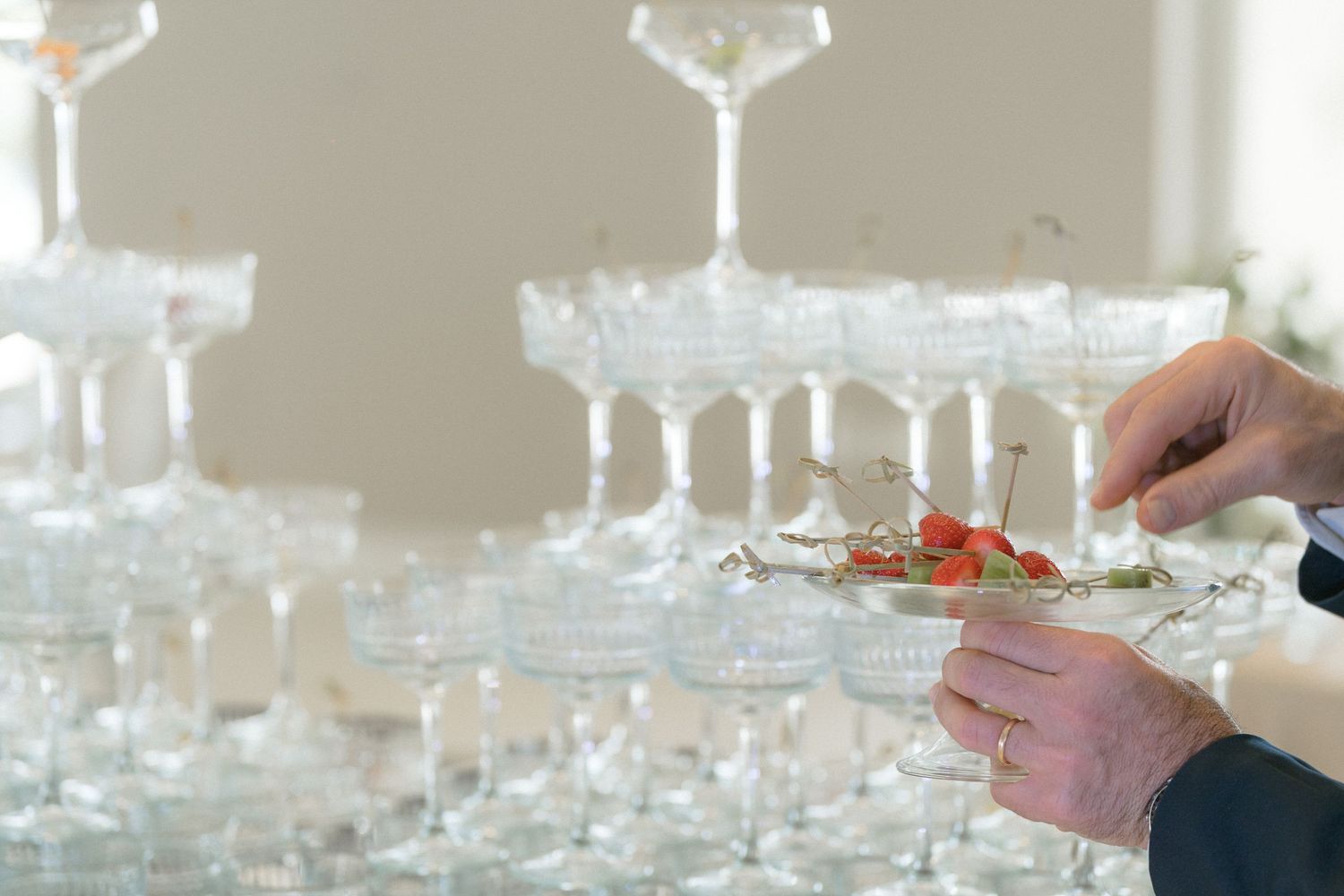 Crystal champagne glasses arranged on table at wedding reception.