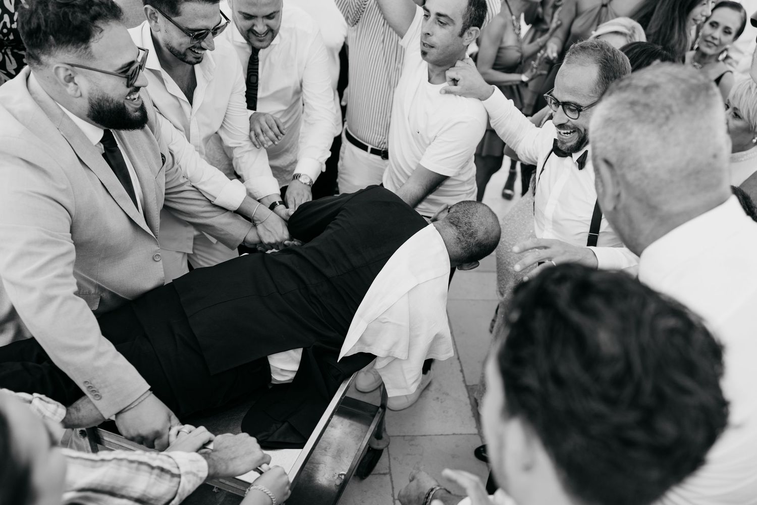 Black and white photo of wedding guests gathered at reception tables.
