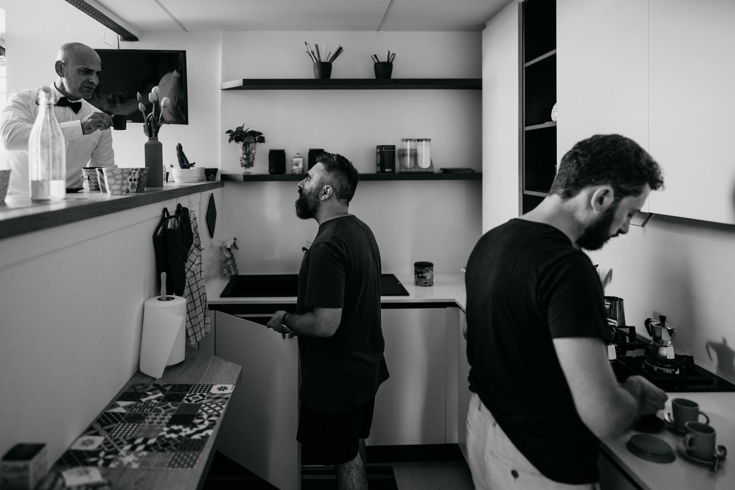 Two people working in a modern kitchen with black and white shelving.