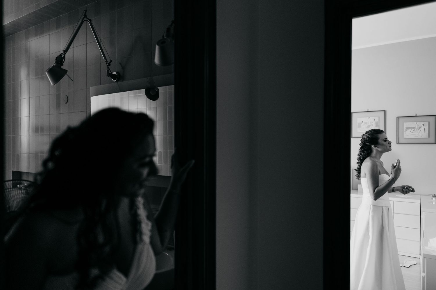 Black and white artistic photograph showing silhouettes and doorway frames in contrasting light.