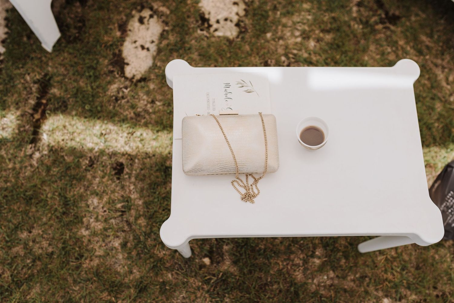 Wedding accessories including jewelry and rings displayed on white surface outdoors.