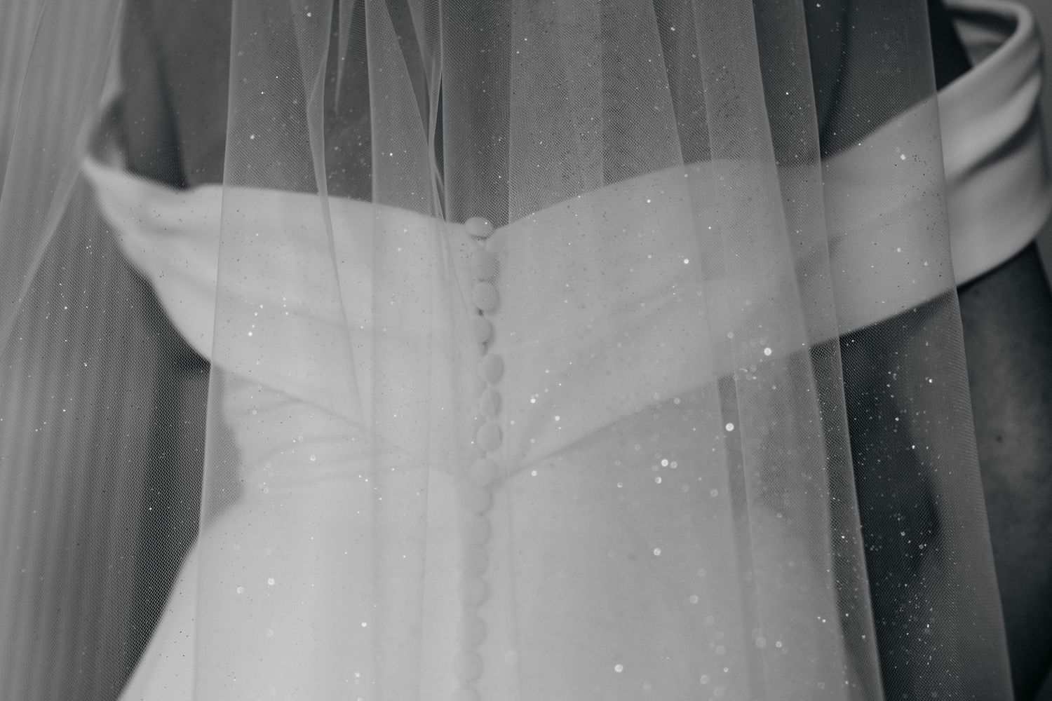 Close-up detail of a white wedding dress fabric and veil.