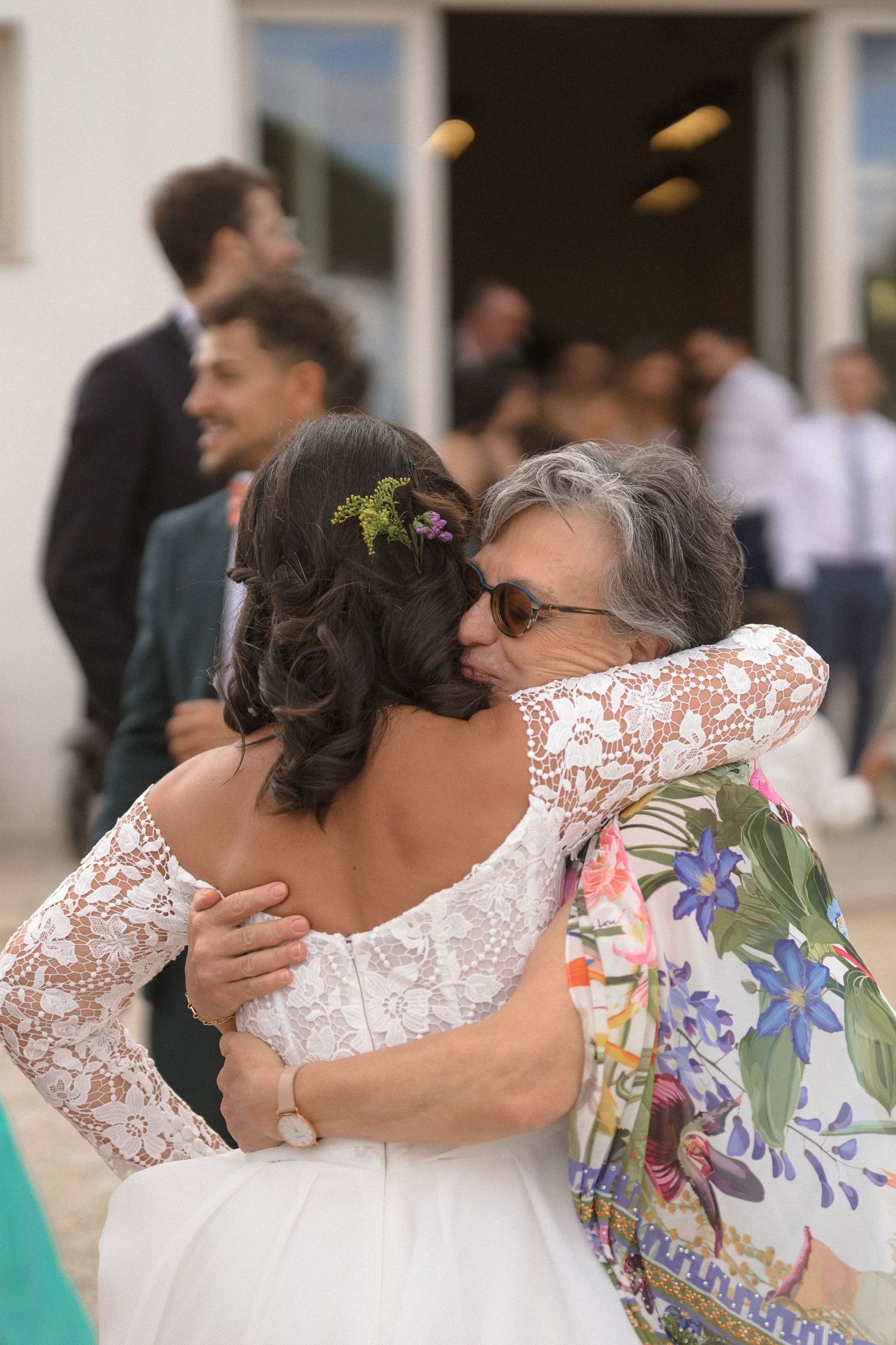 Emotional wedding guests sharing embraces and hugs during celebration.