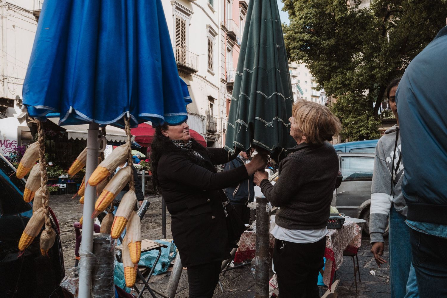 Street vendors selling bright blue dresses and clothing items on outdoor racks.