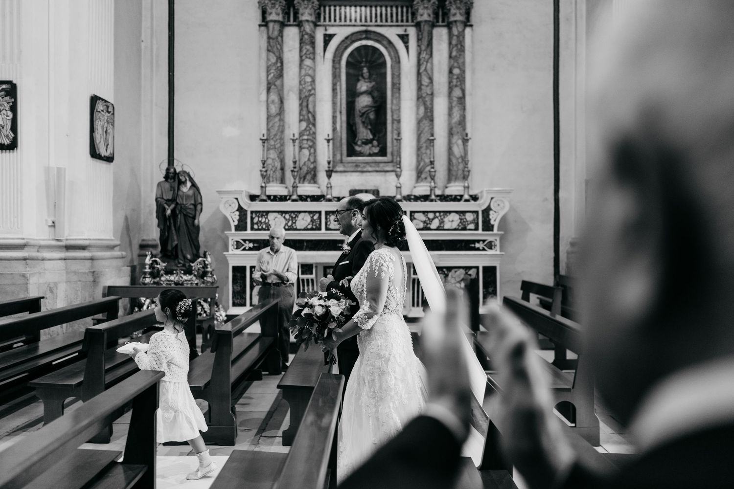 Black and white photograph of a traditional church wedding ceremony showing the altar and pews.