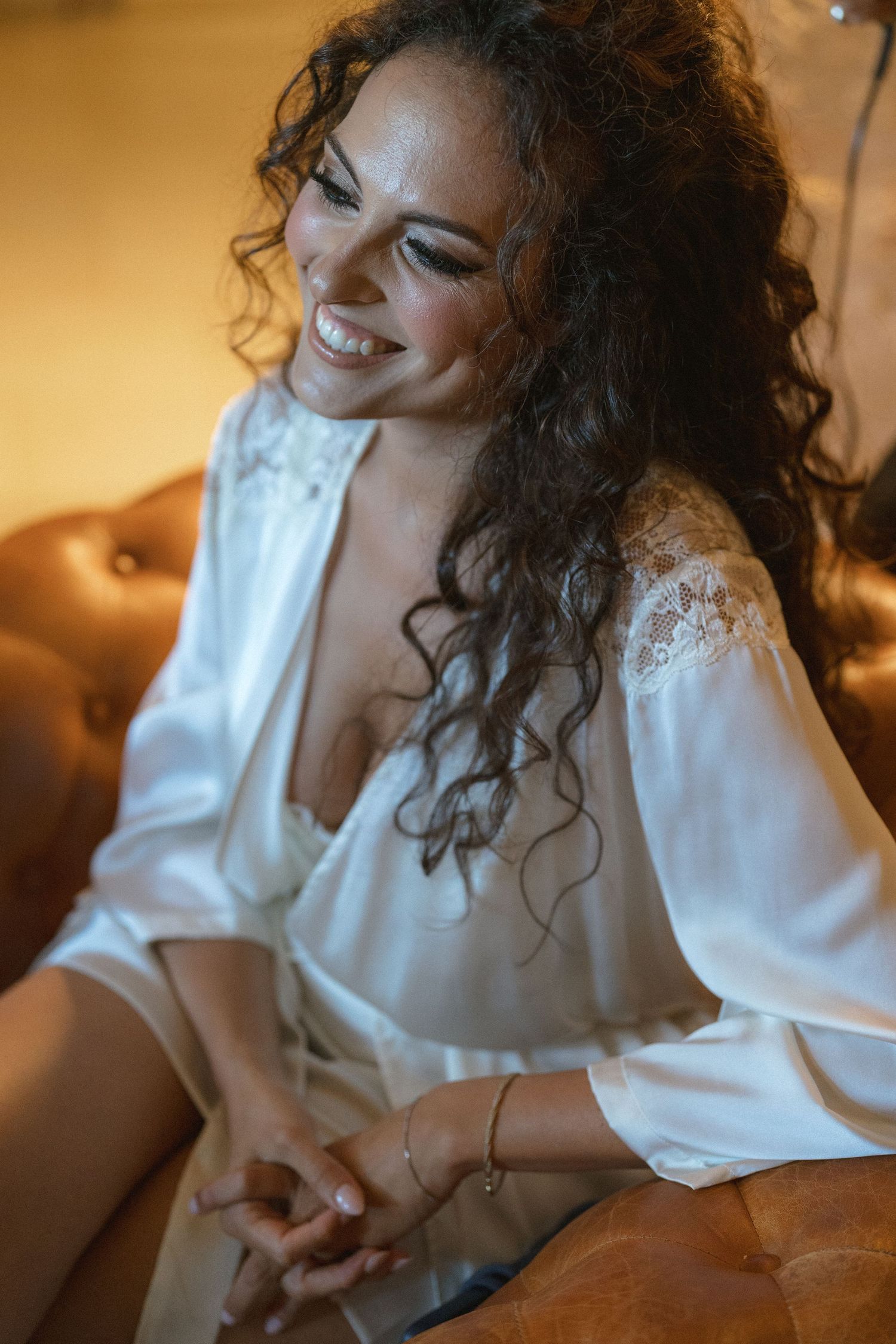 A candid moment showing natural laughter while seated on a leather couch.