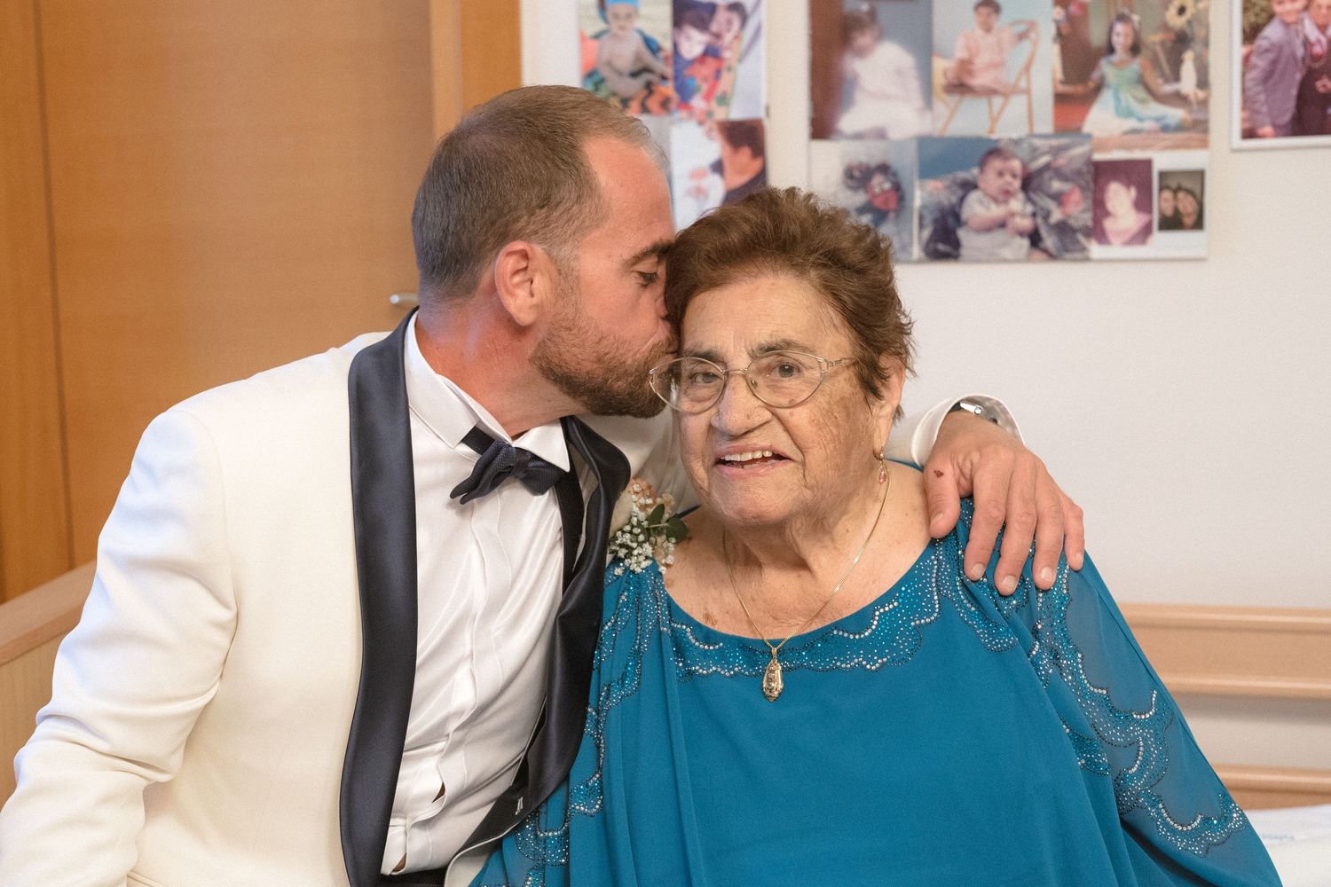 Family members sharing emotional moments during wedding reception in warm indoor setting.