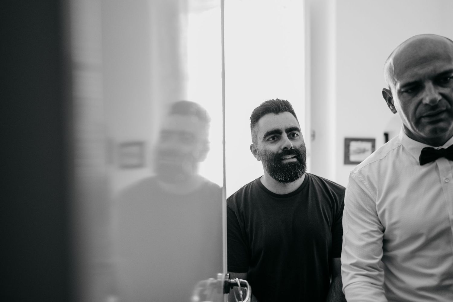 Two people having a conversation in a monochrome interior setting.