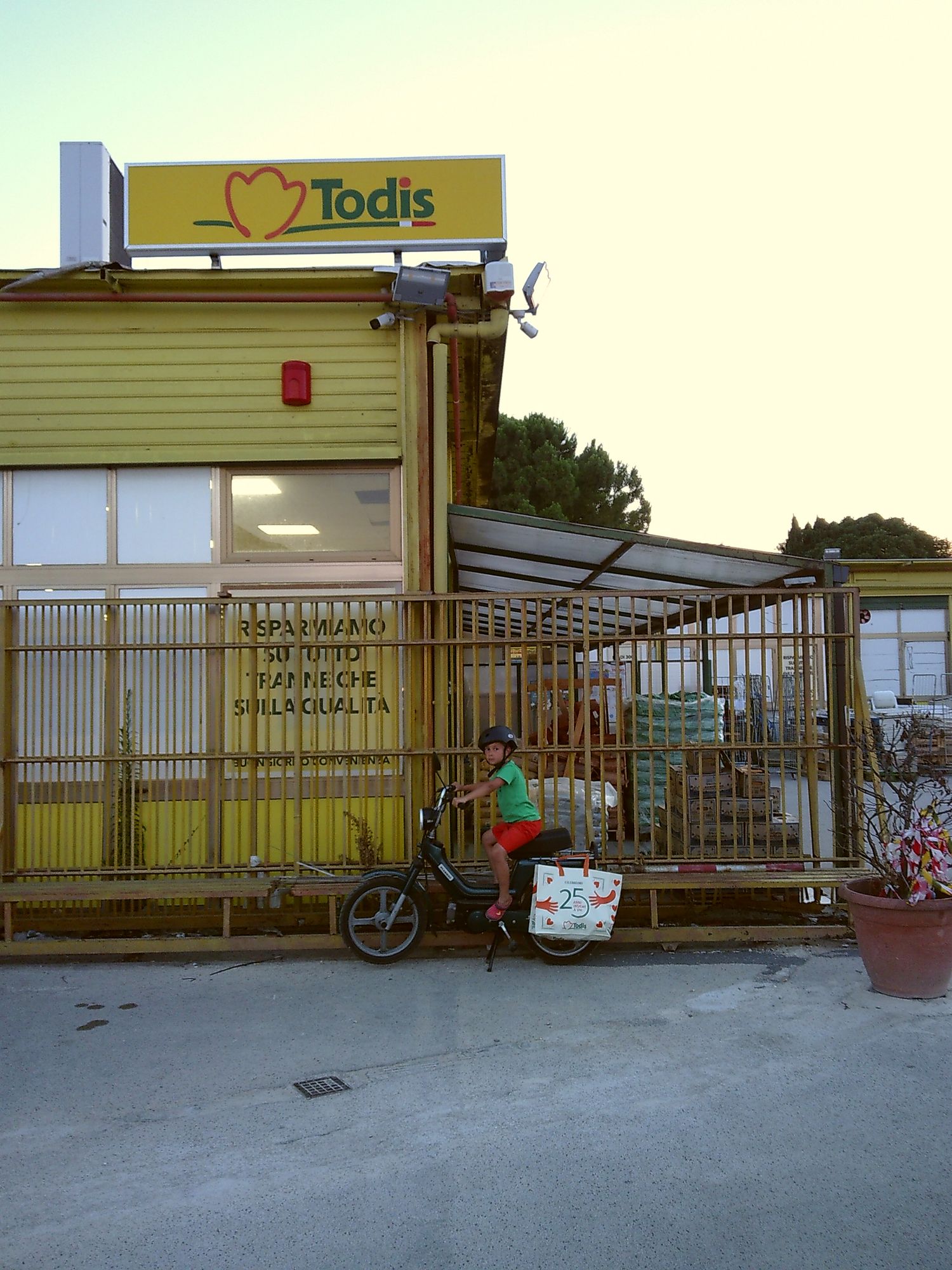 Exterior of Todis store with metal security gates and a bicycle parked outside.