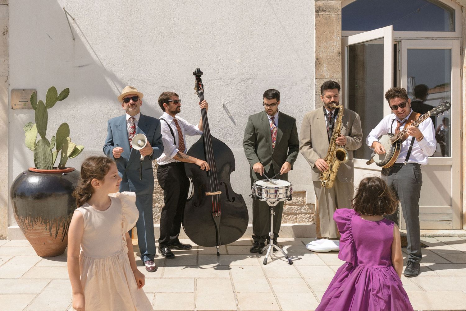 Wedding celebration at a rustic stone venue with guests gathered outside.
