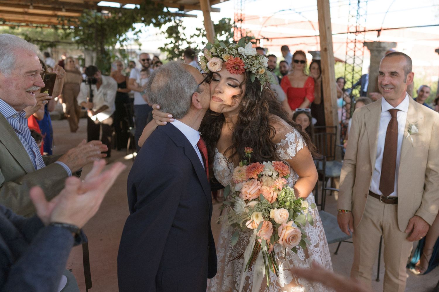 Wedding reception guests mingling under a covered outdoor patio space.