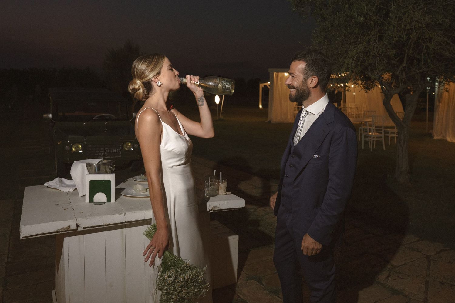 A candlelit evening celebration moment at an outdoor wedding reception.