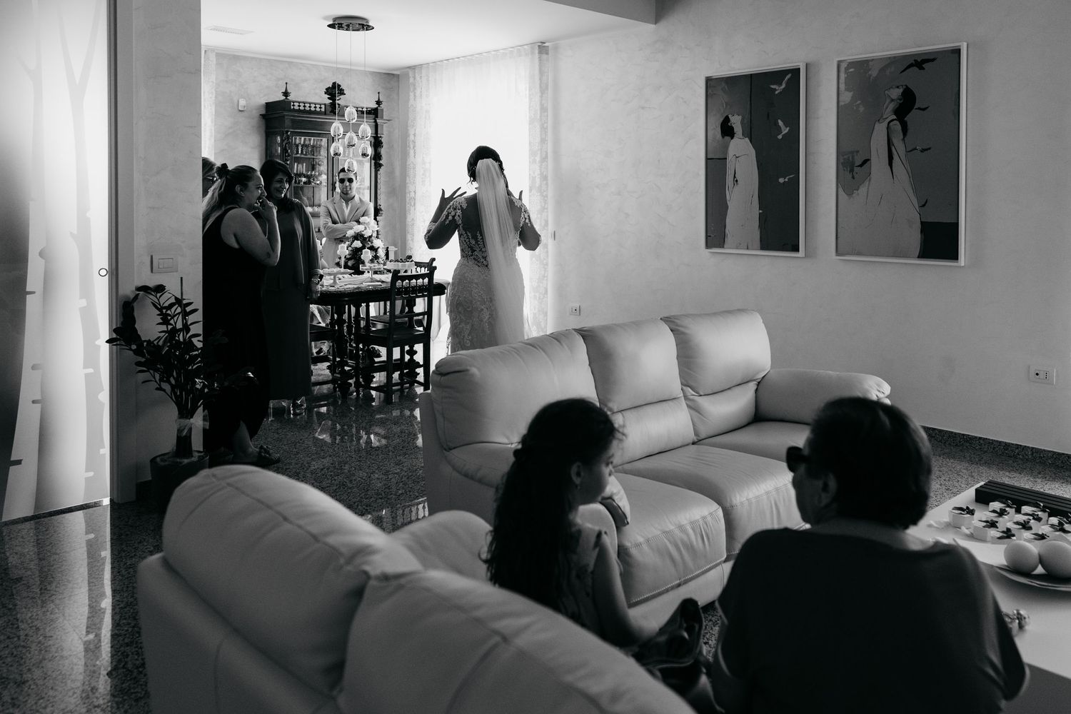 Black and white candid moments from wedding preparations in a cozy indoor setting.