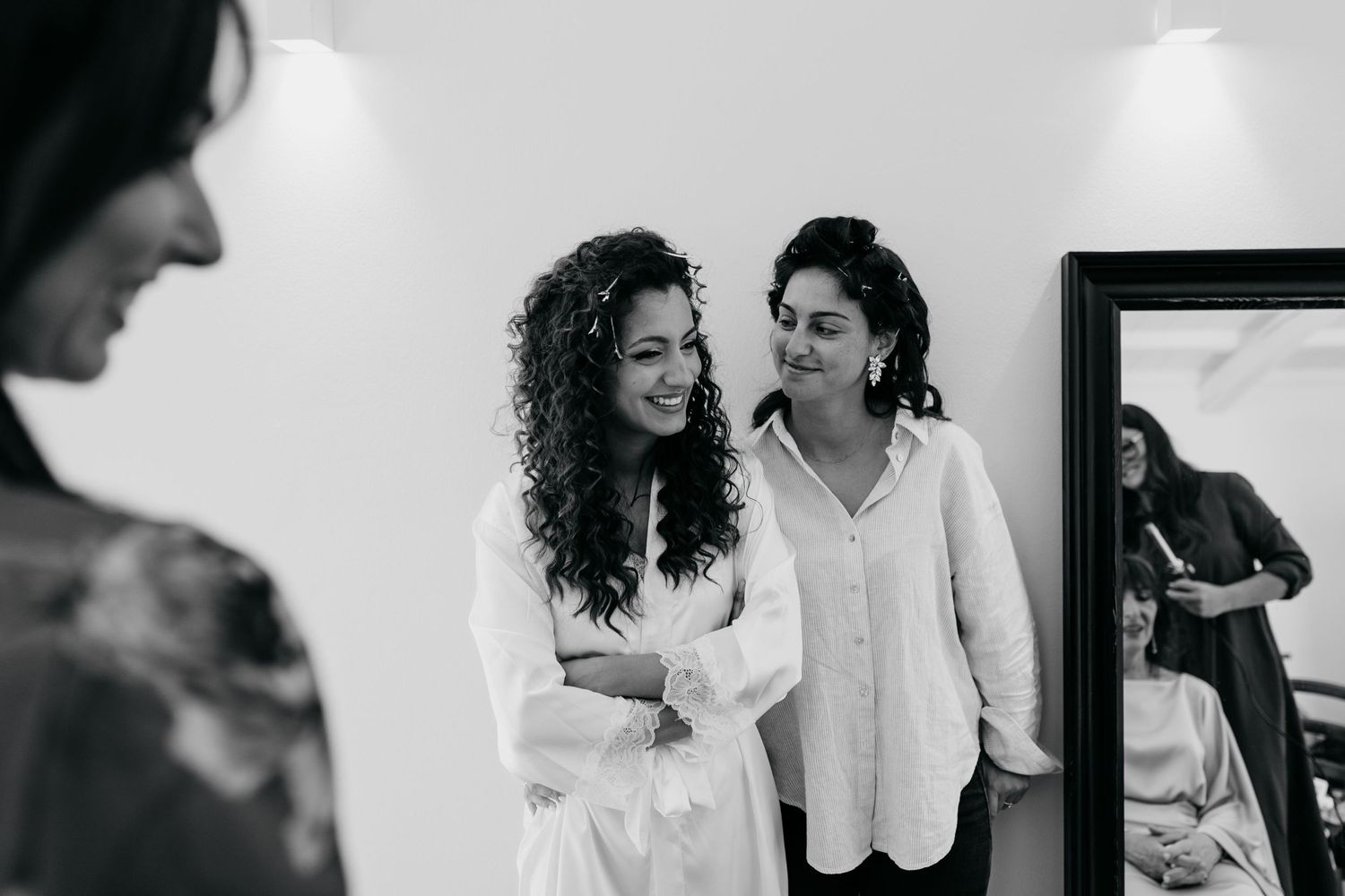 Group of people chatting and laughing together in a bright white room.