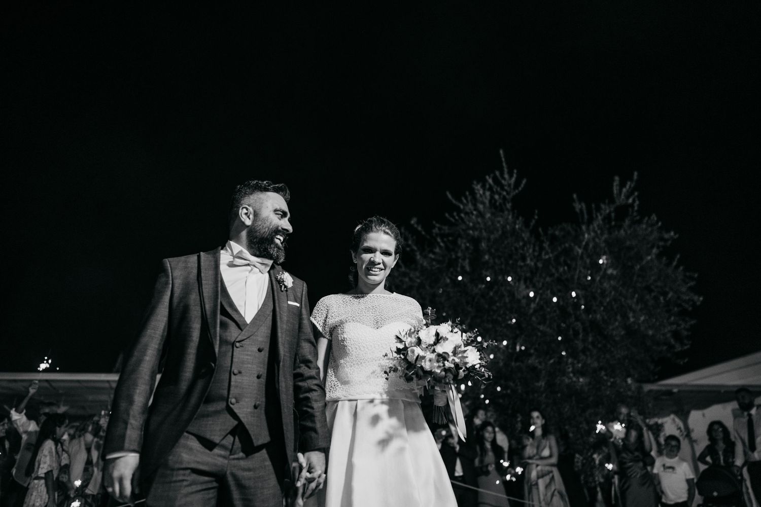 Newlyweds walking together during their evening outdoor celebration.