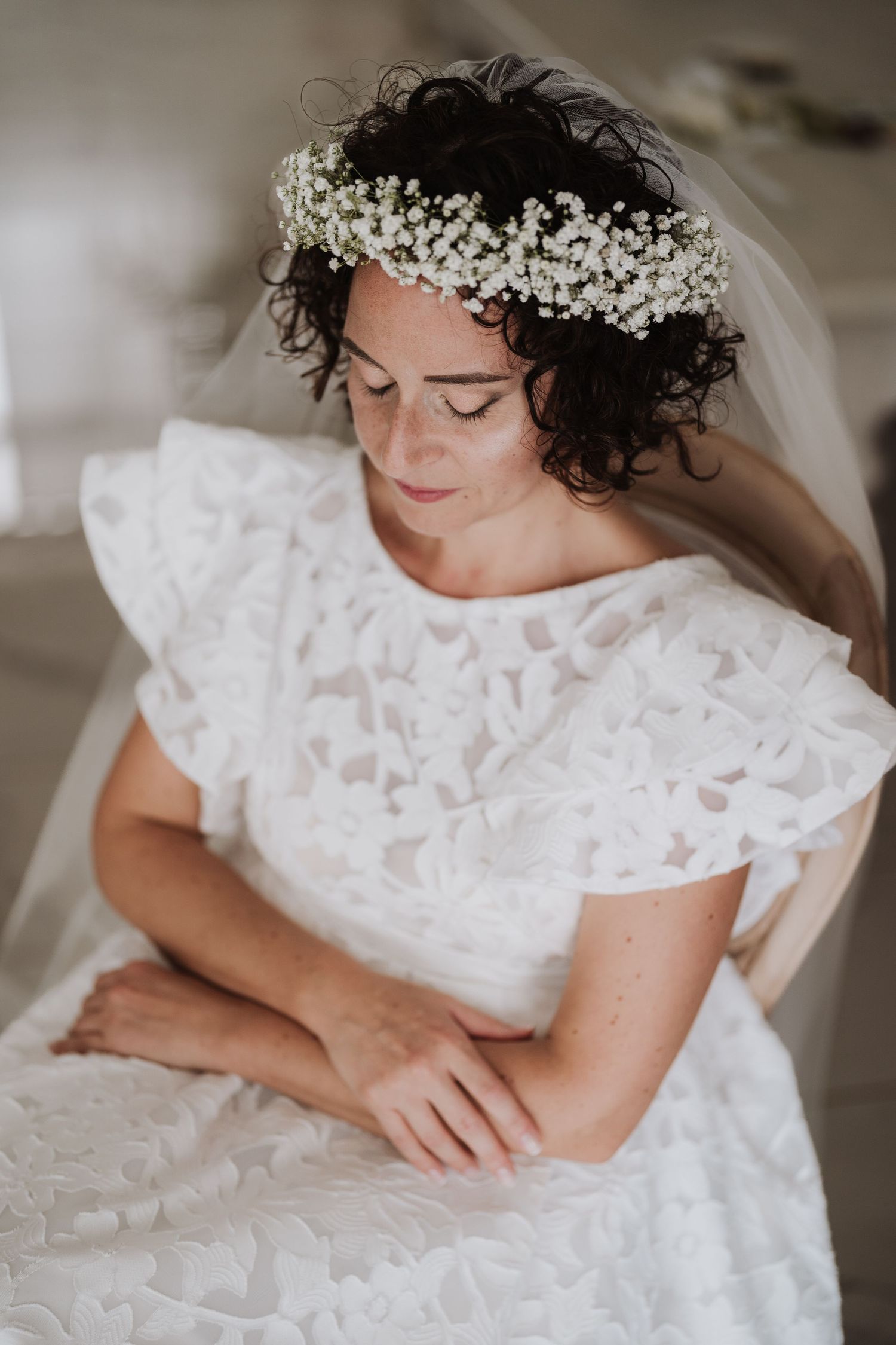 Bridal portrait featuring a baby's breath flower crown and lace dress details.