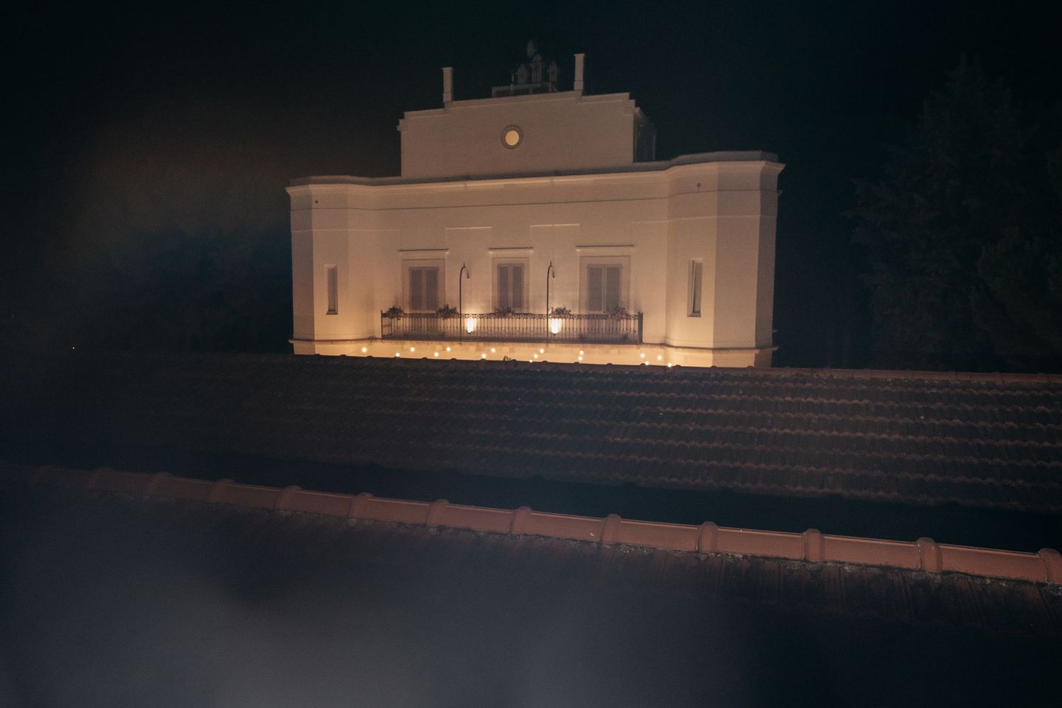 White illuminated building facade at night creating an elegant architectural backdrop.
