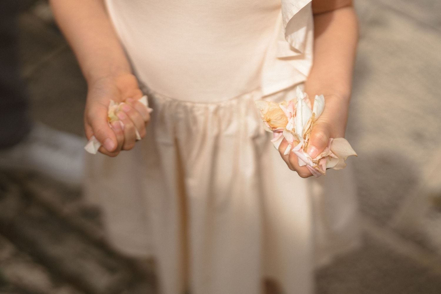 Close-up detail shot of a cream-colored wedding dress fabric and delicate lace details.