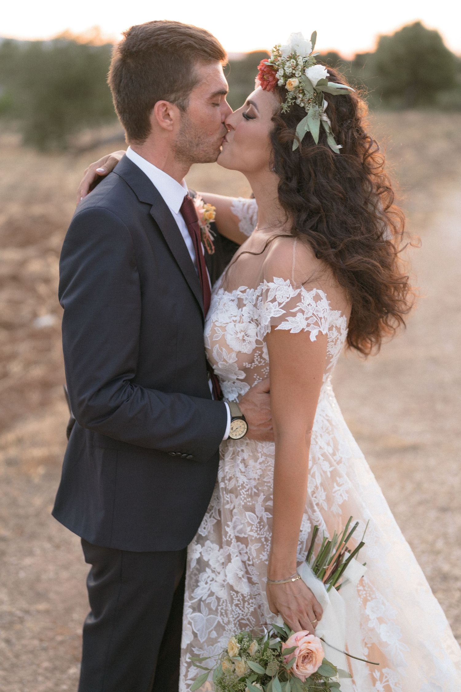 A romantic wedding moment captured at sunset with soft natural lighting and floral details.
