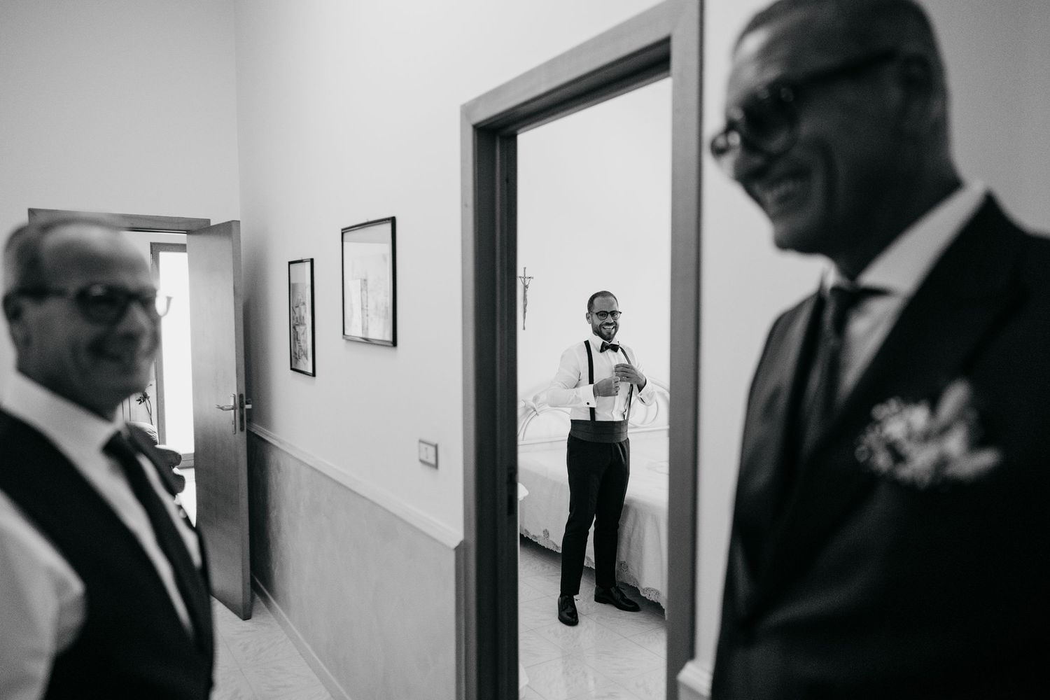 A creative black and white composition showing multiple people through doorways in a hallway.