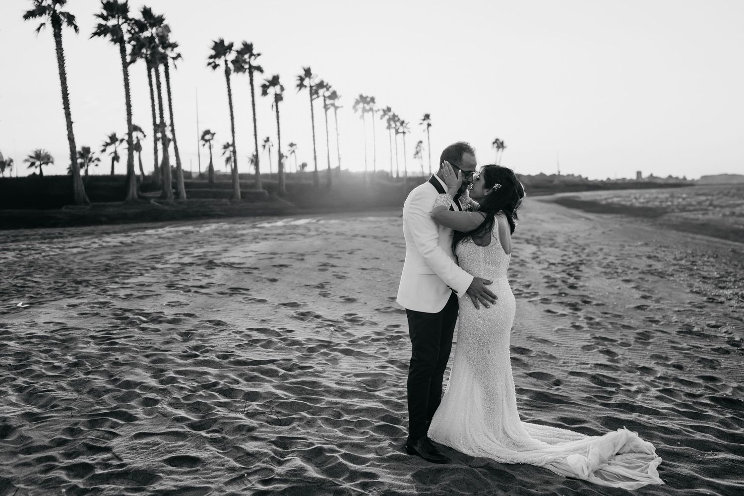 Black and white beach wedding photos with palm trees silhouetted against the sky.