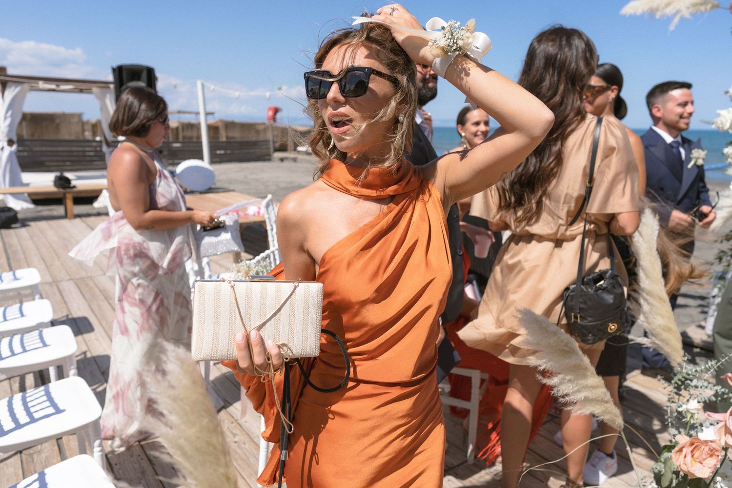 Outdoor wedding guests enjoying a sunny celebration in desert setting with rustic decor.