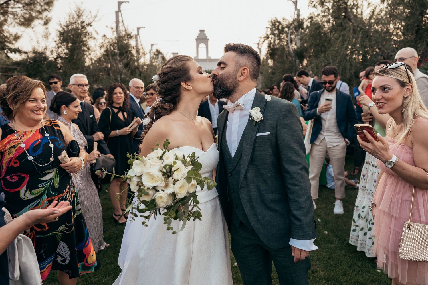 Newlyweds share joyful moment surrounded by celebrating guests with confetti.