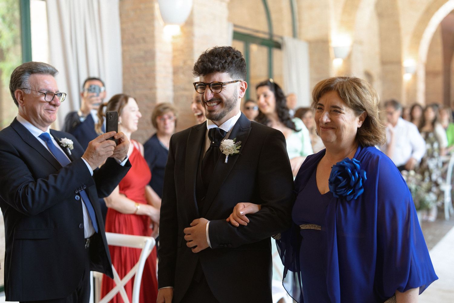 Wedding guests mingle and celebrate in an elegant arched hallway venue.