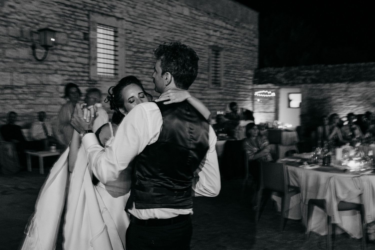 Romantic black and white photograph of a couple dancing at their wedding reception.
