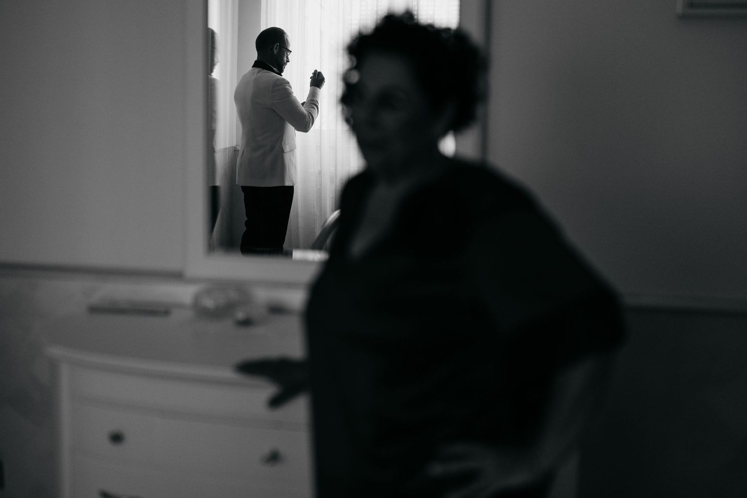 Moody black and white wedding photography sequence with dramatic lighting and silhouettes.