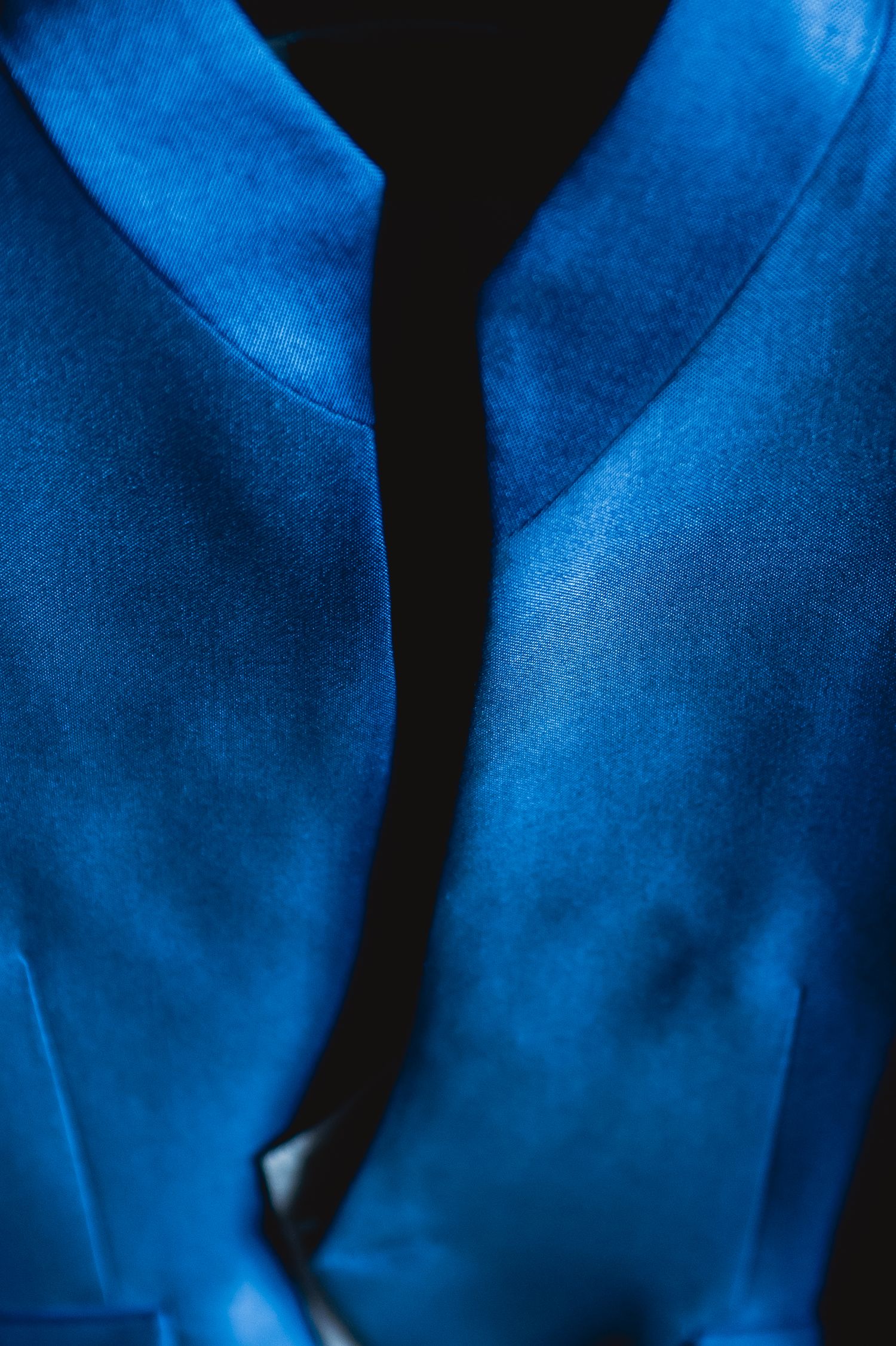 Close-up detail of royal blue satin fabric with a crisp center fold.