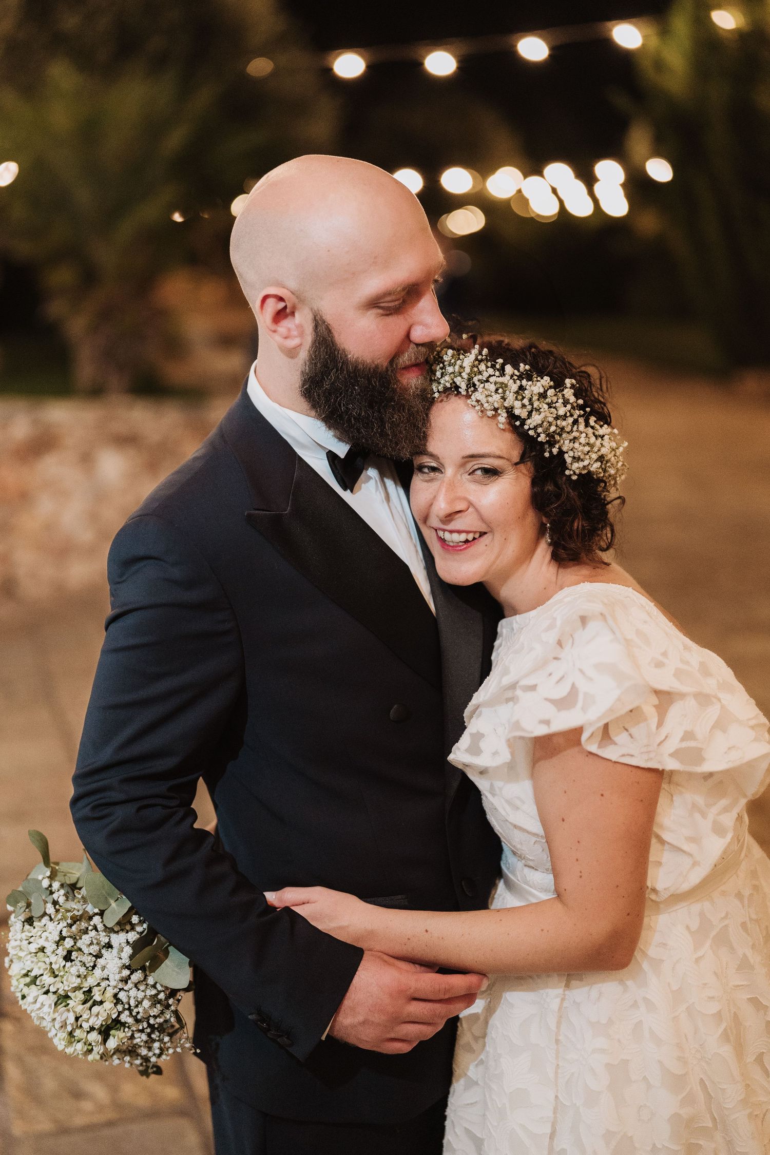 A romantic wedding portrait with baby's breath floral crown under twinkling lights.