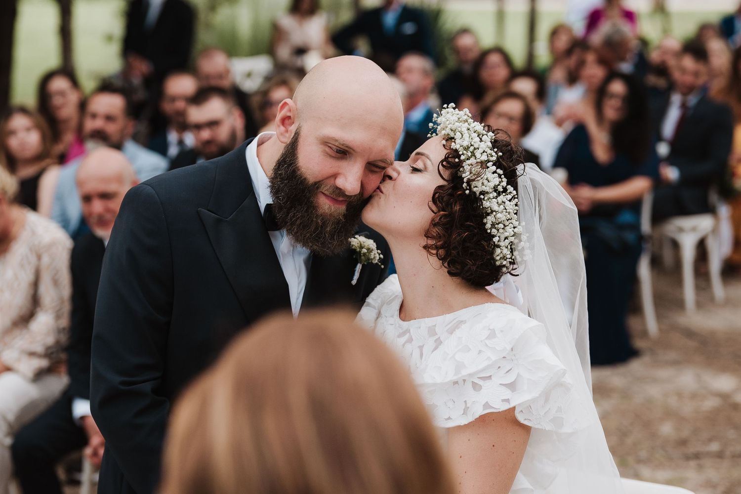 Intimate moment captured between newlyweds during outdoor garden ceremony.