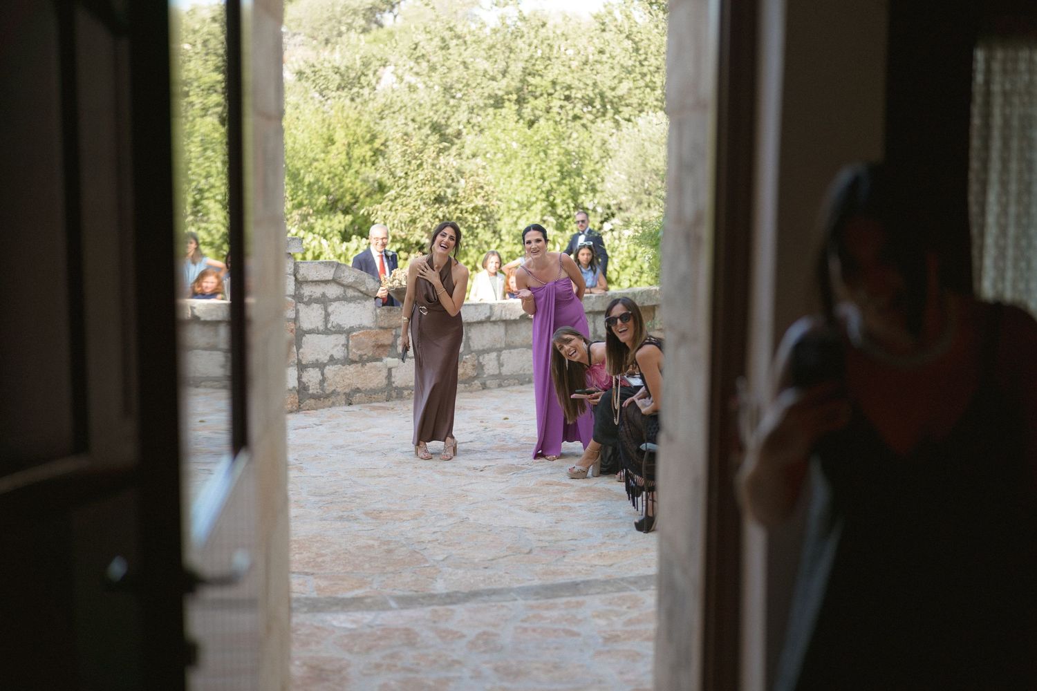 Wedding guests gathered in a stone courtyard during an outdoor celebration.