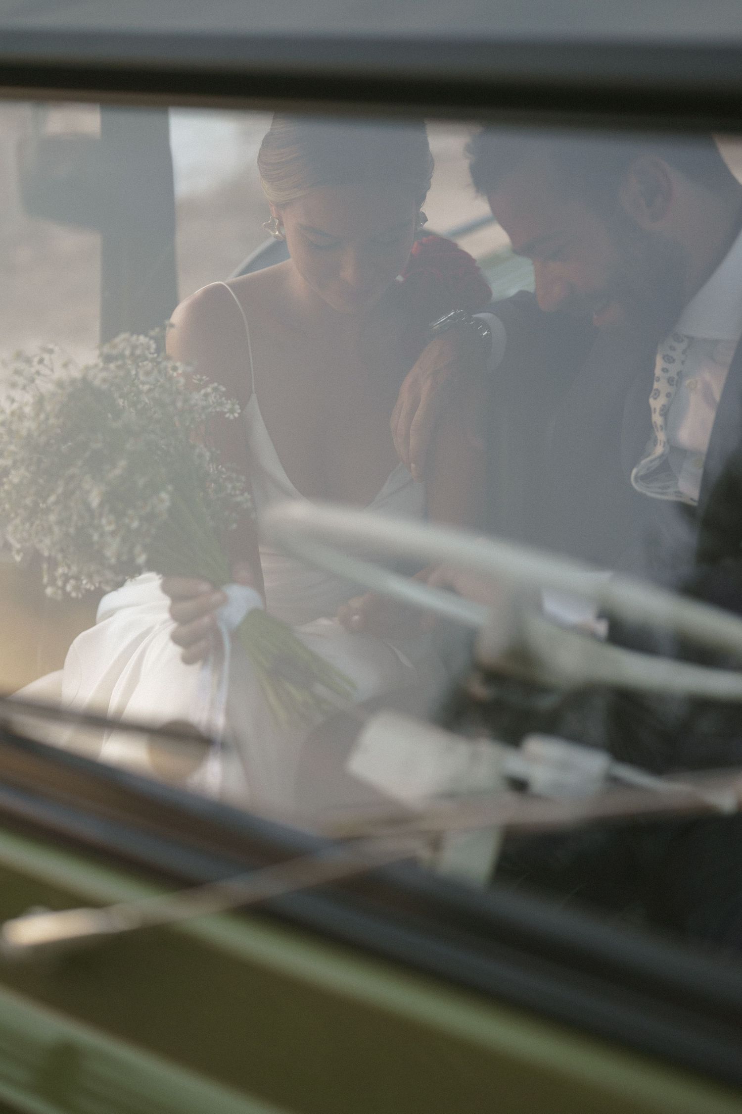 Through a car window, a delicate bouquet of baby's breath flowers is being held.