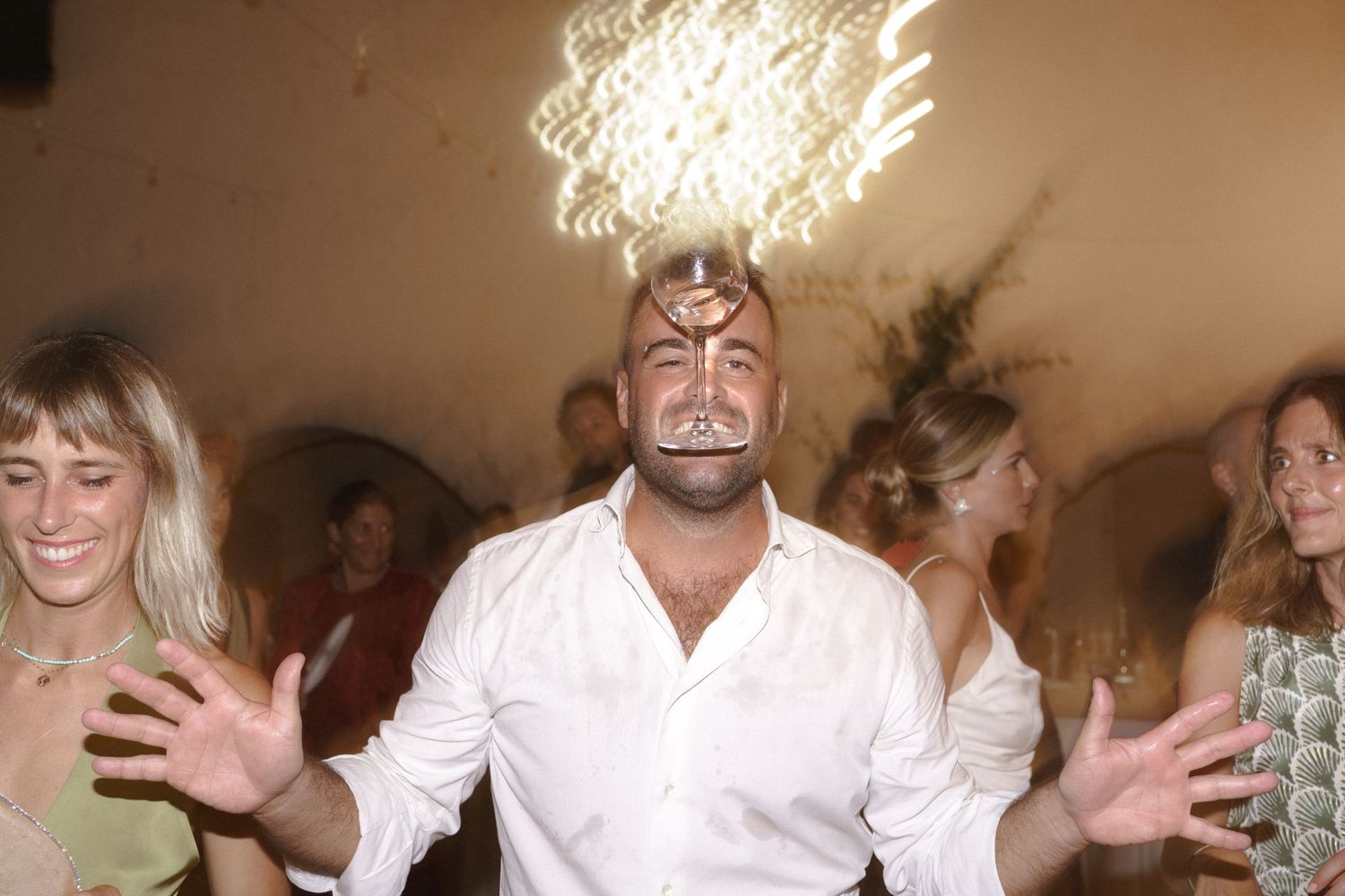 A lively dance party scene with sparkler effects creating light trails in the background.