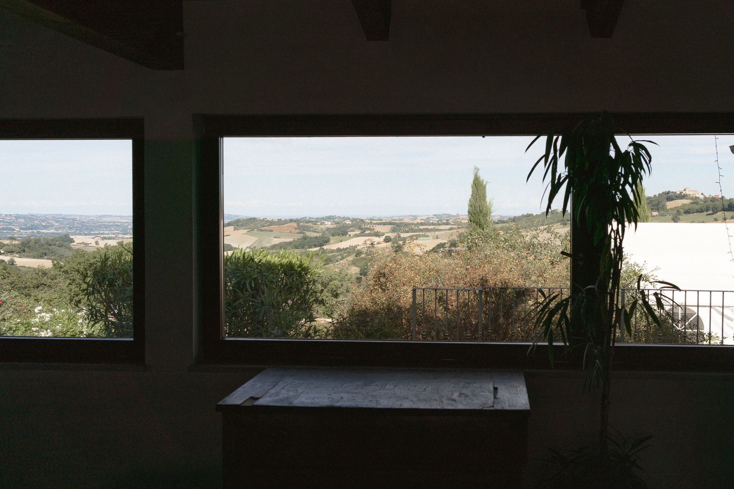 Panoramic view of a countryside landscape through large windows.