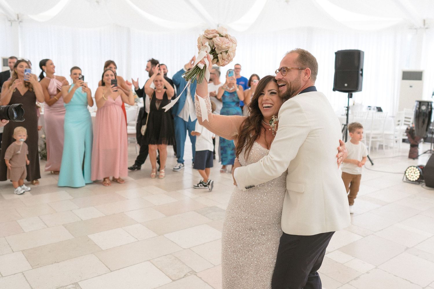 Wedding reception dance floor moment with guests celebrating in formal attire.