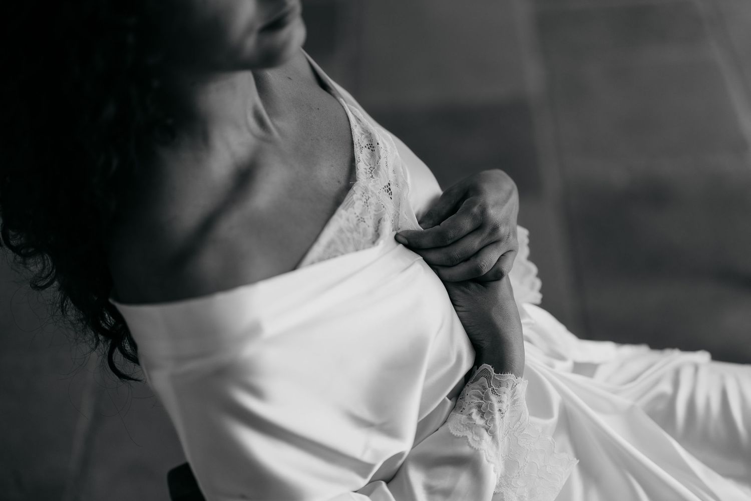 Close-up detail of white fabric being adjusted against a dark background.