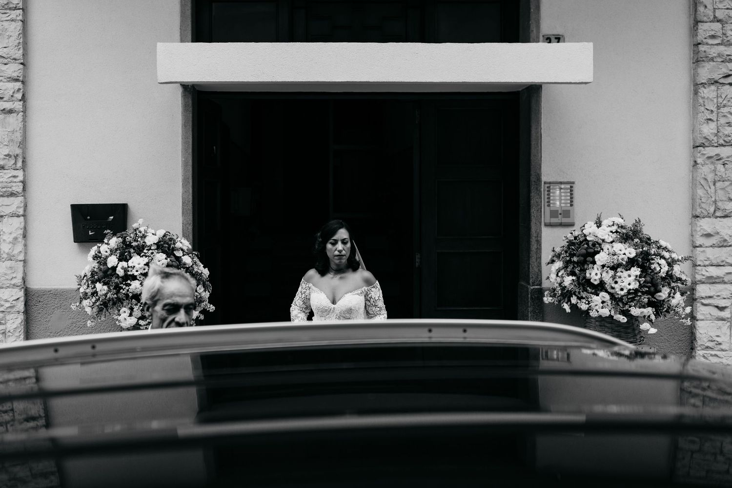 Black and white wedding photograph showing a couple sharing a romantic moment at an outdoor venue.